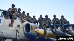 Пілоти Повітряних сил ЗСУ позують для фото, сидячи на штурмовику Су-25, на своїй базі на сході України, 4 травня 2023 року. Фото ілюстративне
