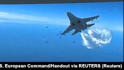 Російський літак Су-27 скидає паливо під час польоту на американський БПЛА MQ-9 над Чорним морем, 14 березня 2023 року
