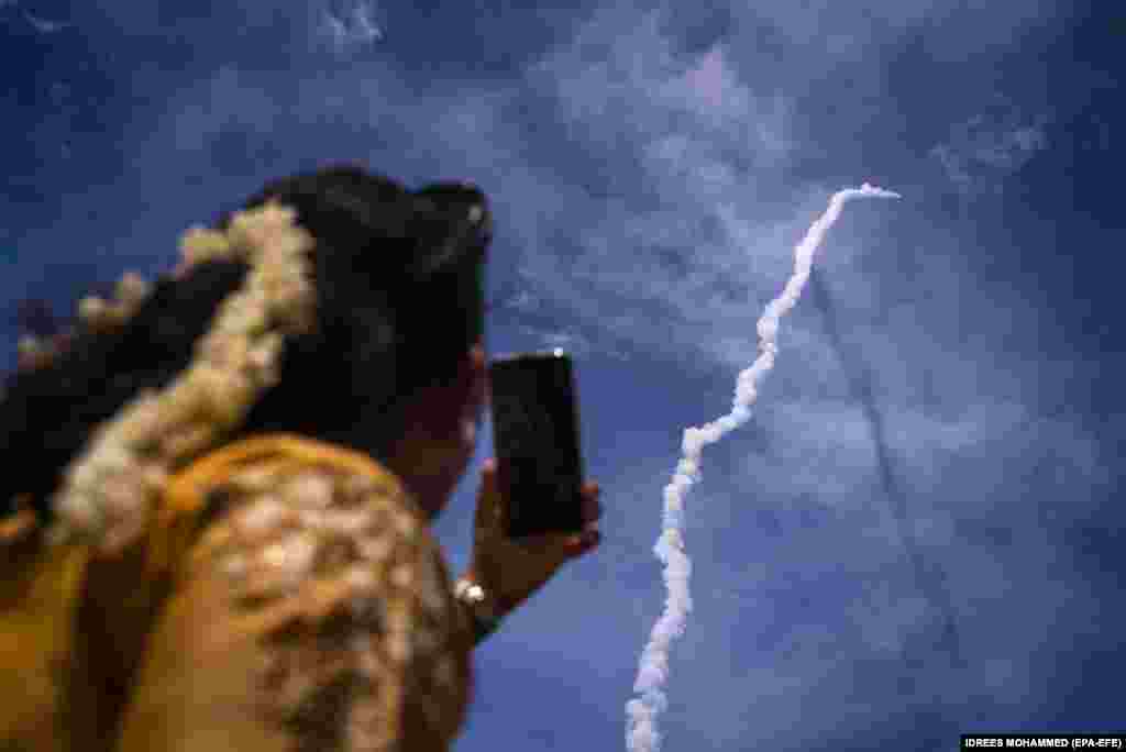Raýat Hindi kosmos gözleg guramasynyň (ISRO) Çandrayaan-3 (Aý ulagy-3) gämisiniň Satiş Dhawan kosmos merkezinden ýokary göterilişine tomaşa edýär. Hindistanyň günortasyndaky Andra Pradeş welaýatynda ýerleşýän Sriharikota, 2023-nji ýylyň 14-nji iýuly. 75 million dollardan az býudjet bilen gurlan guraly arkaly hindi kosmos gullugy aýa gonmaga we Amerikanyň Birleşen Ştatlary,&nbsp;öňki Sowet Soýuzy we Hytaý ýaly ýurtlaryň tejibesini gaýtalamaga synanyşýar.&nbsp;(EPA-EFE/IDREES MOHAMMED)