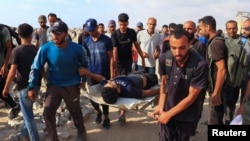 Palestinci nose ranjenog mladića u Beit Lahiji, u Pojasu Gaze, 23. juna 2025. godine.