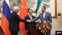 Russia's Deputy Foreign Minister Sergei Ryabkov (left), China's Executive Vice Minister of Foreign Affairs Ma Zhaoxu (center), and Iran's Deputy Foreign Minister Kazem Gharibabadi hold a press conference in Beijing, March 14