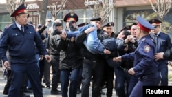 Алматыда полиция Гоголь мен Панфилов көшелерінің қиылысында жүрген адамды ұстап әкетіп барады.
