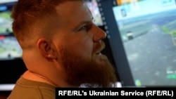 Un soldat ucrainean se uită la imaginile care arată pozițiile rusești care pot fi țintite de artilerie.