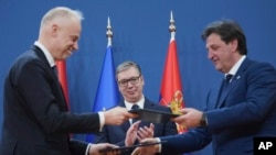 Aleksandar Vucic szerb elnök (középen) figyeli, ahogy a magyar (b)és a szerb honvédelmi miniszter kicseréli a két ország katonai együttműködéséről szóló megállapodás dokumentumát 2025. április 1-én